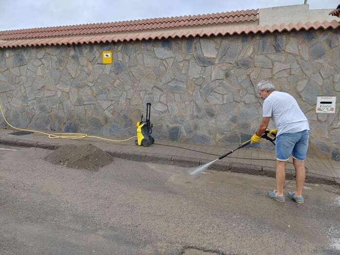 Julián Domínguez, limpiando la calle Clavel con ayuda de una pistola de agua a presión (Foto TA)